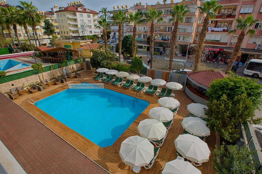 阿拉尼亚HMA Hotel & Suites的享有带遮阳伞和椅子的游泳池的顶部景致