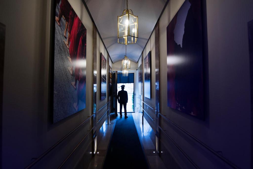 罗马托雷阿根廷和莱 - 魅力宅区酒店的走在走廊走廊上的男人