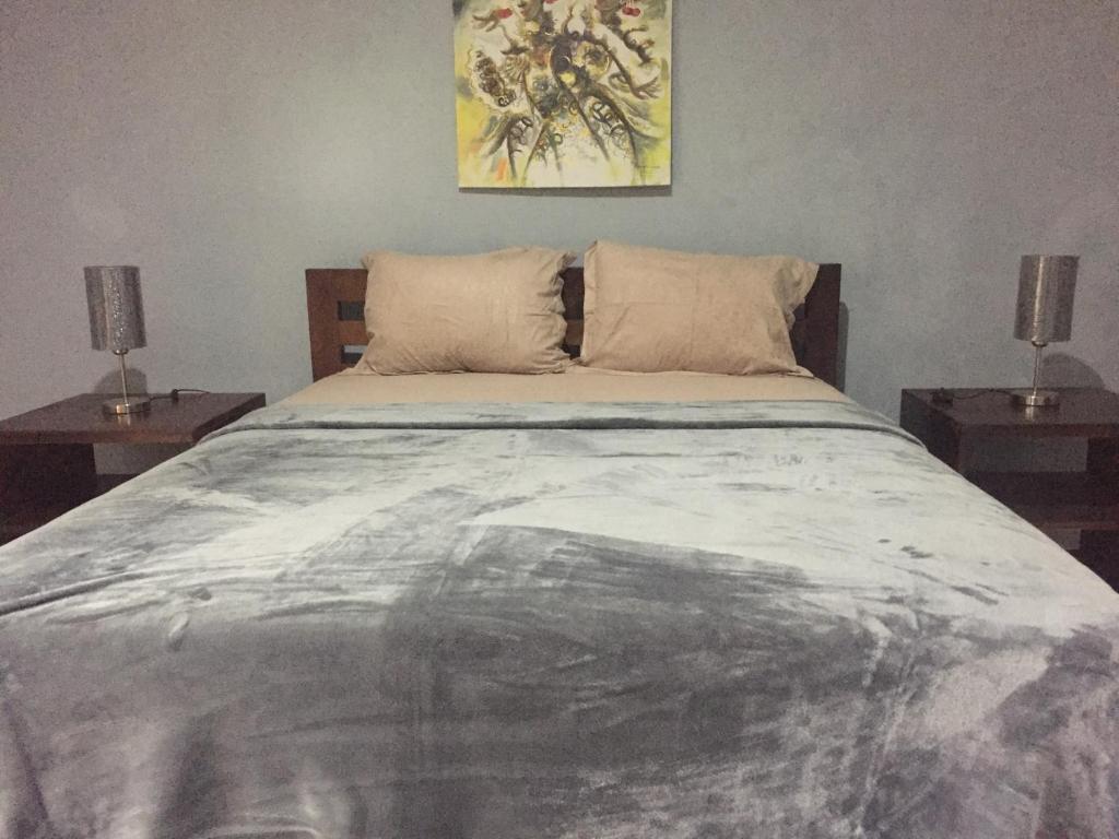 乌鲁瓦图Cempaka Homestay的一间卧室配有一张带两张桌子的床
