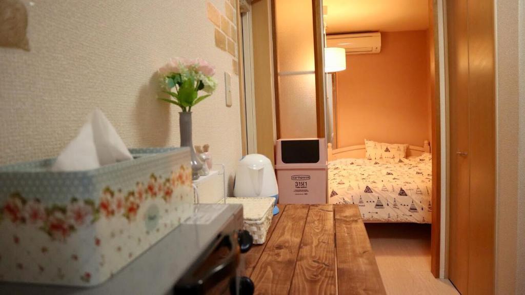 神户Mori de house in kobe202的客房设有带一张床和一张桌子的卧室
