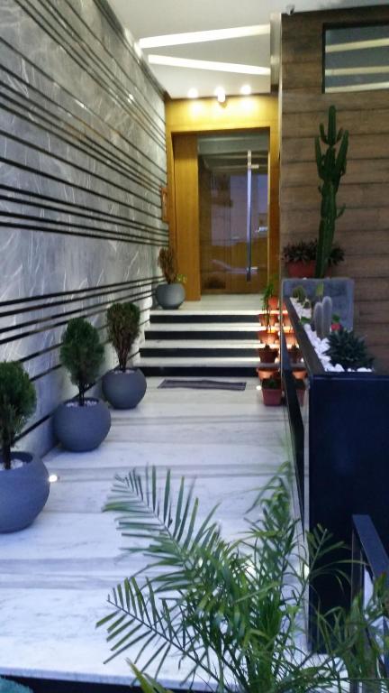 盖尼特拉Golden Ashraf Apartment的大厅里种有盆栽植物和楼梯