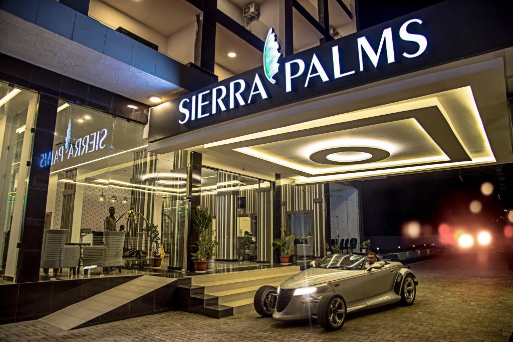 弗里敦Sierra Palms Resort的停在商店前的汽车