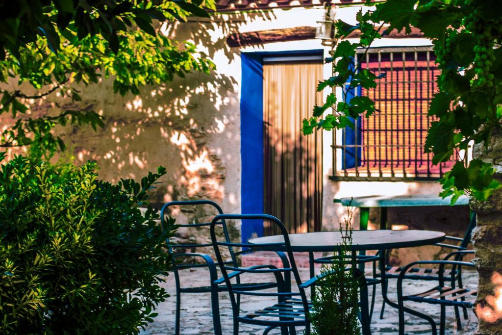 CarcelénCasas Rurales Tío Segundo的一个带蓝色门的庭院里的桌椅
