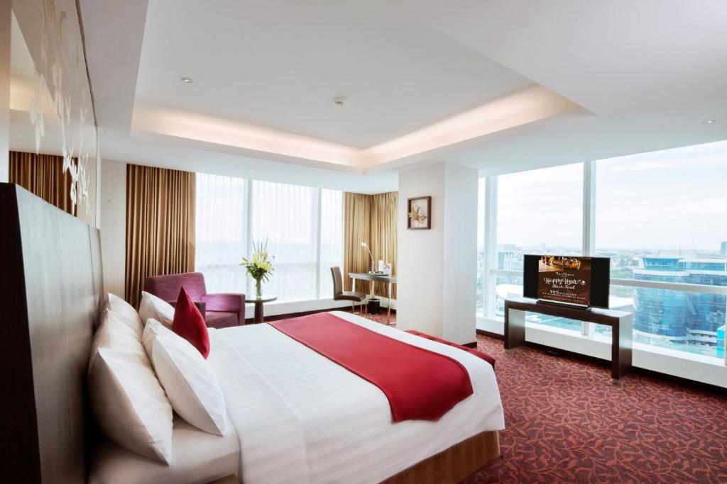 泗水泗水阿拉纳酒店的酒店客房设有一张床和一个大窗户