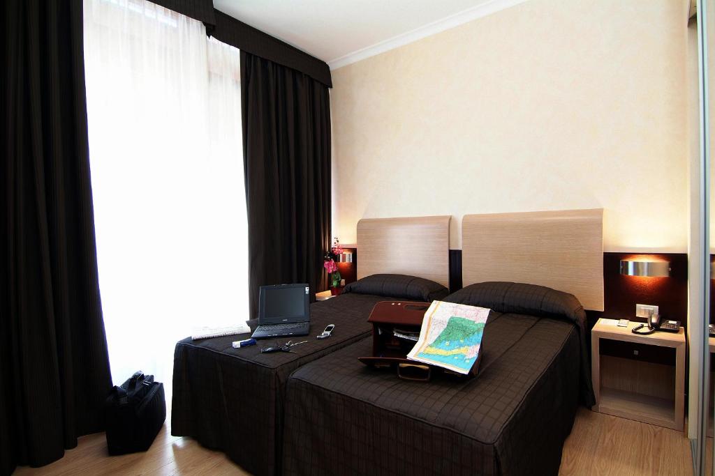 菲乌米奇诺EH Rome Airport Euro House Hotels的一间卧室配有一张带笔记本电脑的床