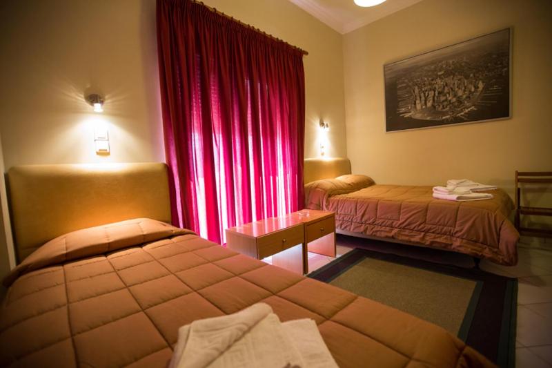 纳弗帕克托斯尼基酒店的酒店客房,设有两张床和红色窗帘