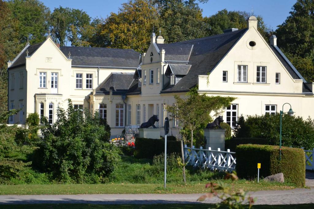 WalkendorfFerienGut Dalwitz Gutshaus的黑色屋顶的白色房子