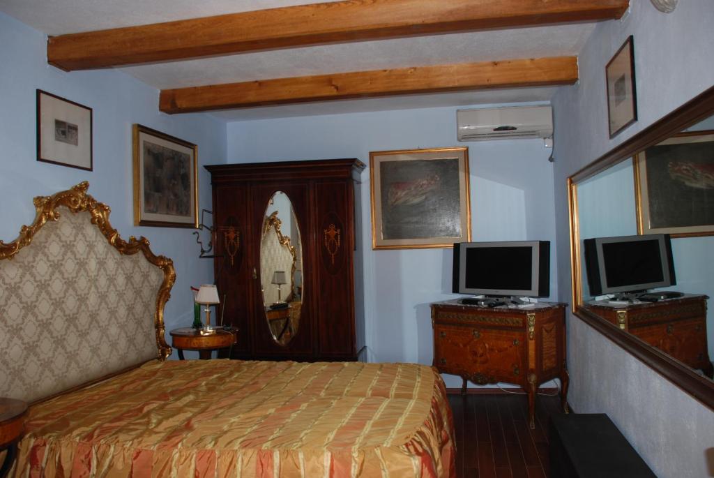 IslazVilla Giulia的一间卧室配有一张床和一张书桌及电视