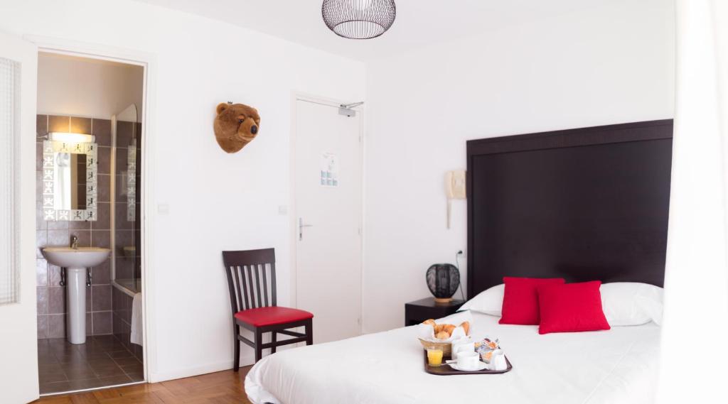 戛纳艾斯佩兰托酒店的卧室配有带红色枕头的大型白色床