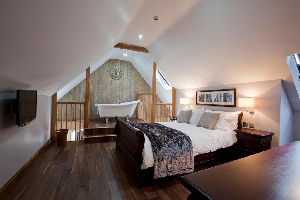 Cerne AbbasThe New Inn的卧室配有床和浴缸