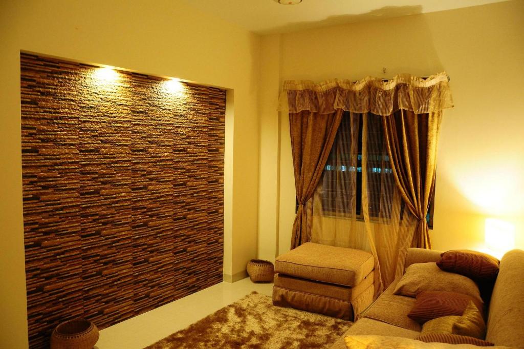 达卡Rajanigandha Family Suites的带沙发和大窗户的客厅