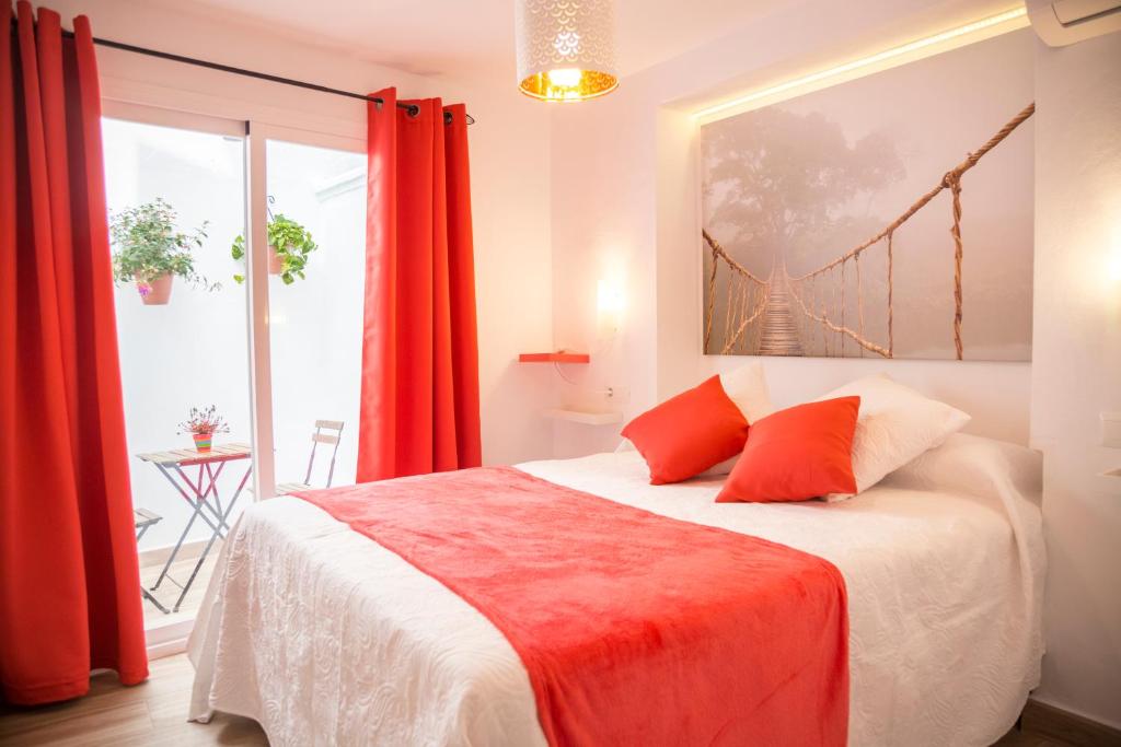 孔佩塔La Casa Del Recreo的一间卧室配有一张带红色窗帘的大床