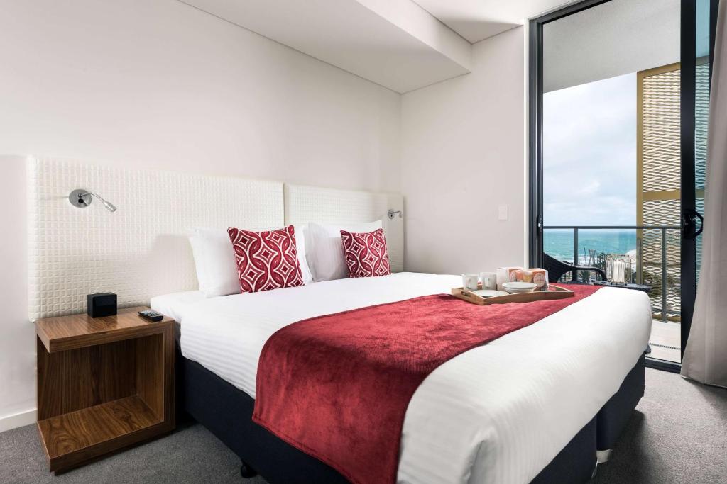 珀斯维特罗布鲁士嘉堡海滩华美达酒店的一间卧室设有一张大床和一个大窗户