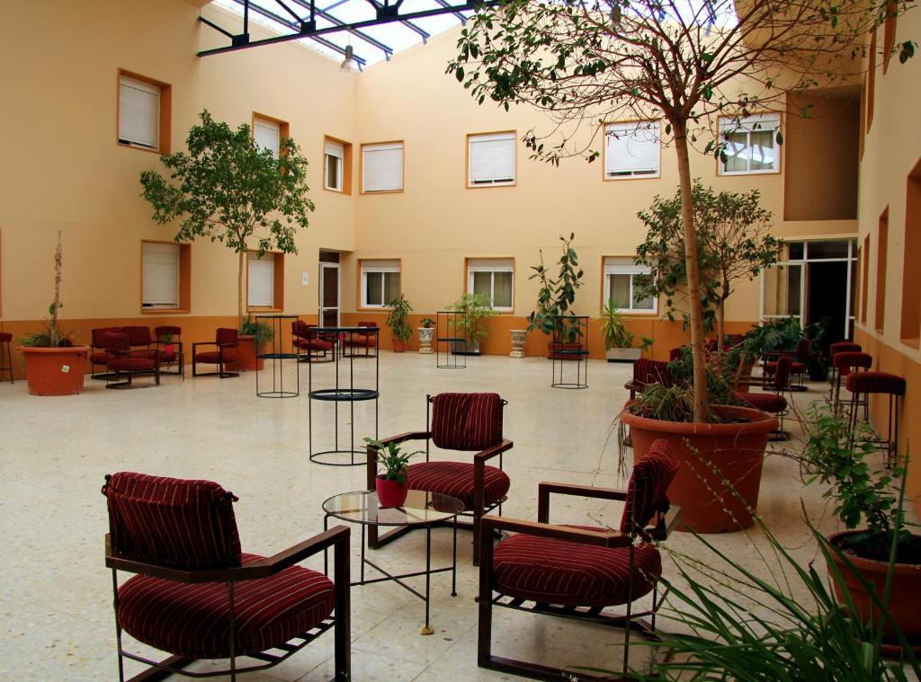 卡塞雷斯AHC酒店的建筑里带椅子和树木的房间