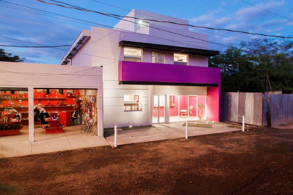 马那瓜Airport Inn Managua的一座带车库的紫色外墙房子