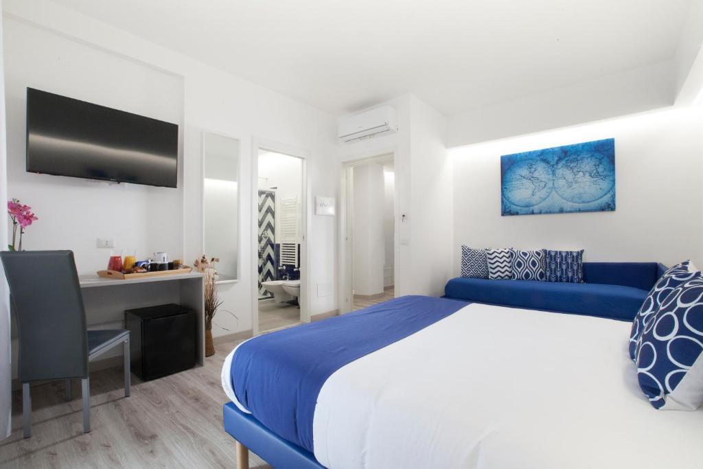 圣安吉洛Sirocco Suites的卧室配有蓝色和白色的床和书桌。