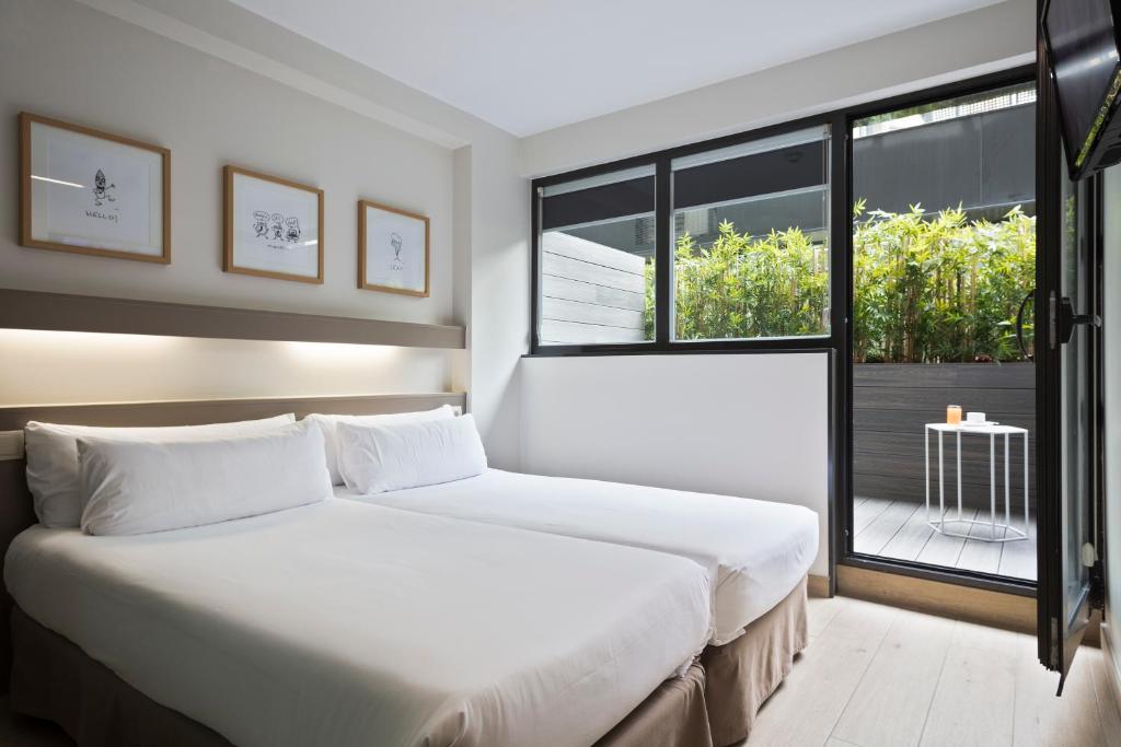 巴塞罗那蒙特胡依克公寓式酒店的卧室设有一张白色大床和一扇窗户。