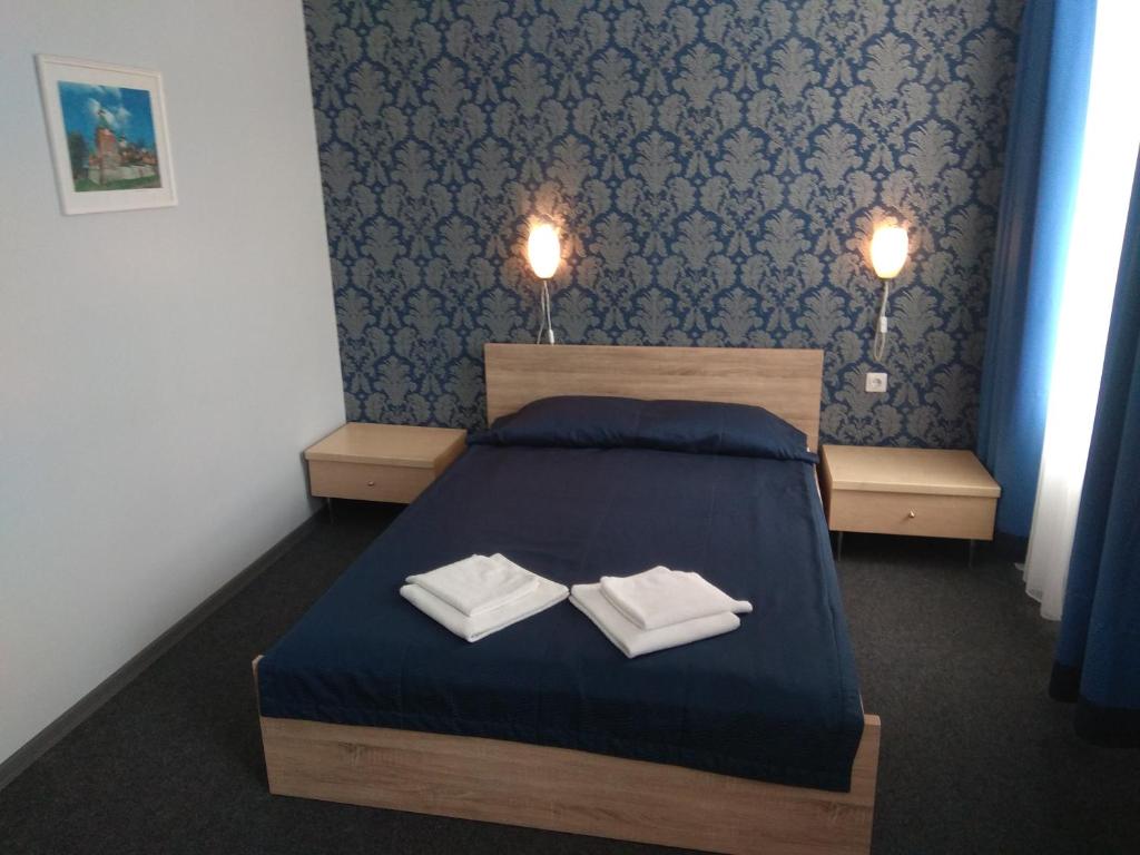 科赫特拉-耶尔韦Alex Hotel的一间卧室配有一张床,上面有两条毛巾