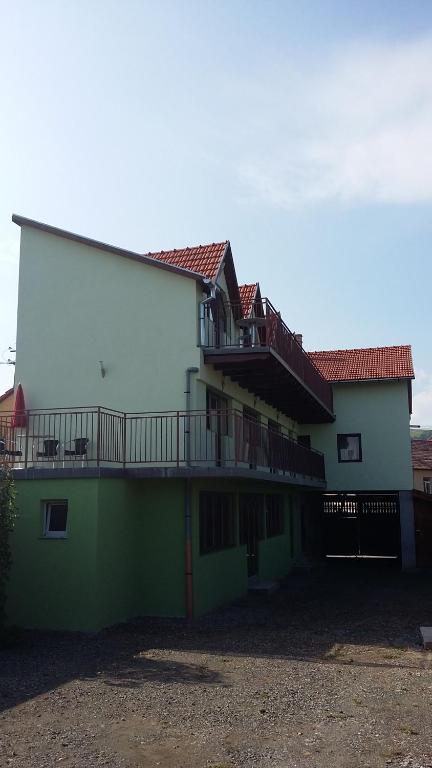 Luna de SusPensiunea Casa Szabi的带阳台的绿色白色建筑