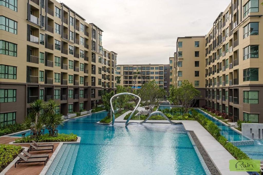 七岩华欣爱雨公寓的两个公寓大楼中间的一个游泳池