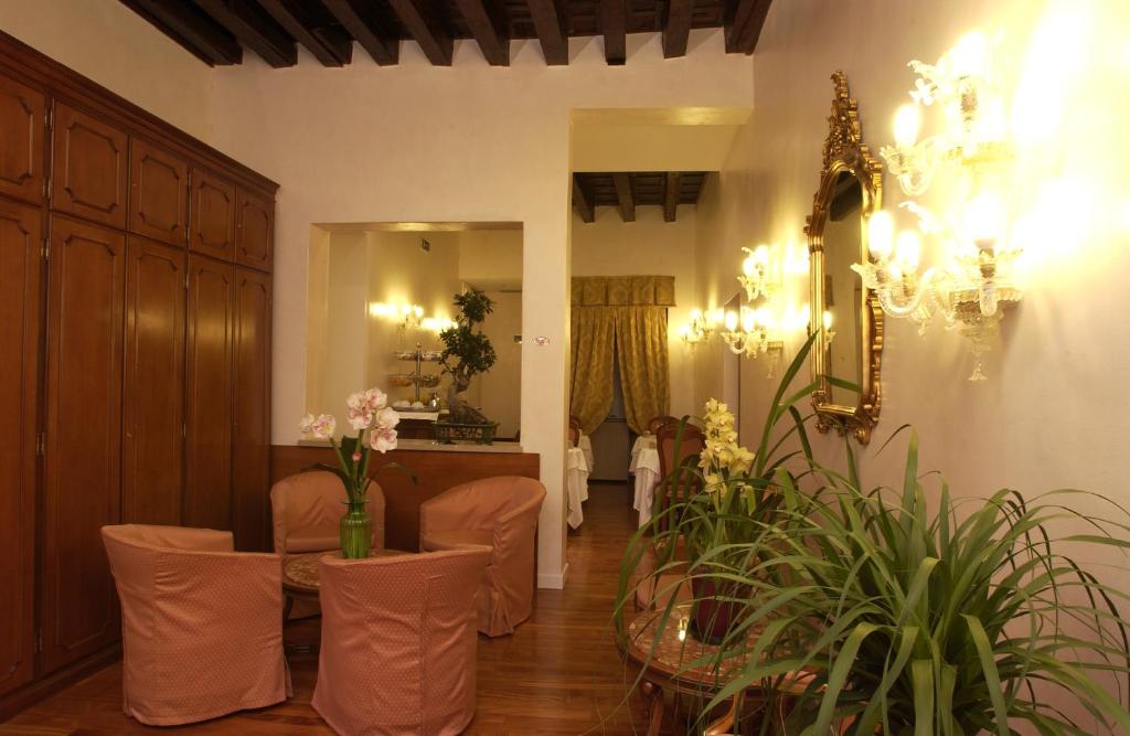 威尼斯坎达运河酒店的一个带椅子和鲜花的候客室的沙龙
