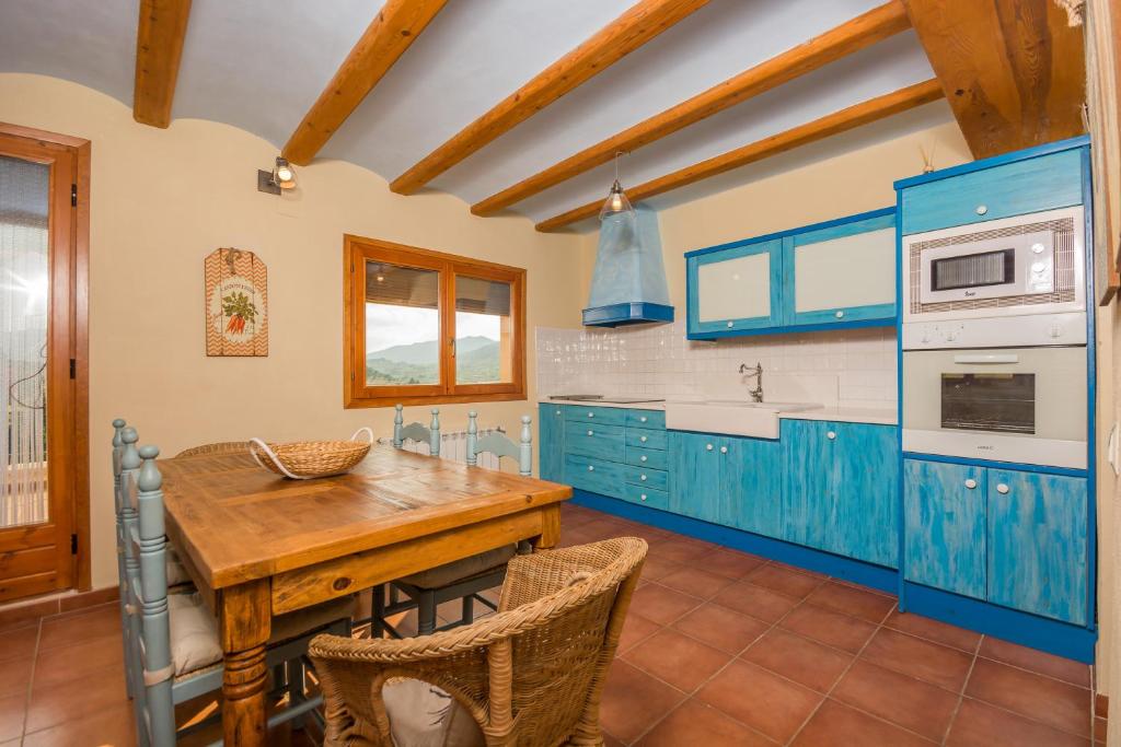 贝塞特Casas Lo Tossal的厨房配有蓝色橱柜和木桌