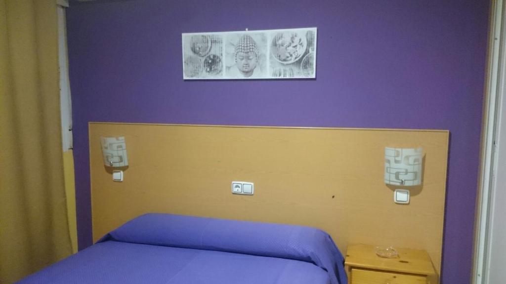 贝利利亚·德·圣安东DS旅馆的一间设有一张紫色和黄色床铺的客房