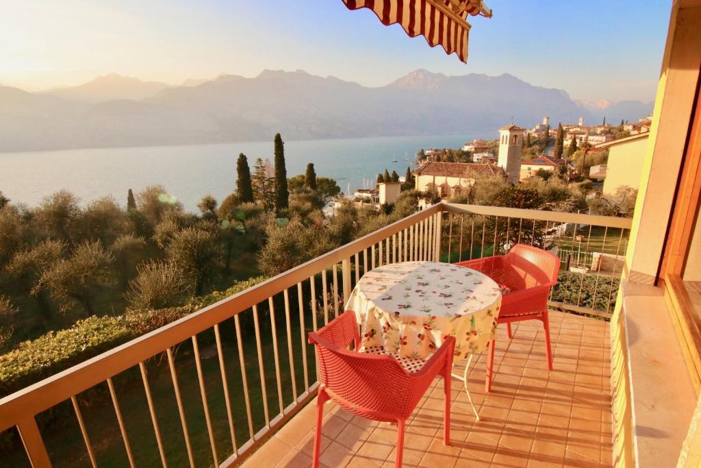 马尔切西内Apartament Magnific Lake View的阳台配有桌椅,享有水景。