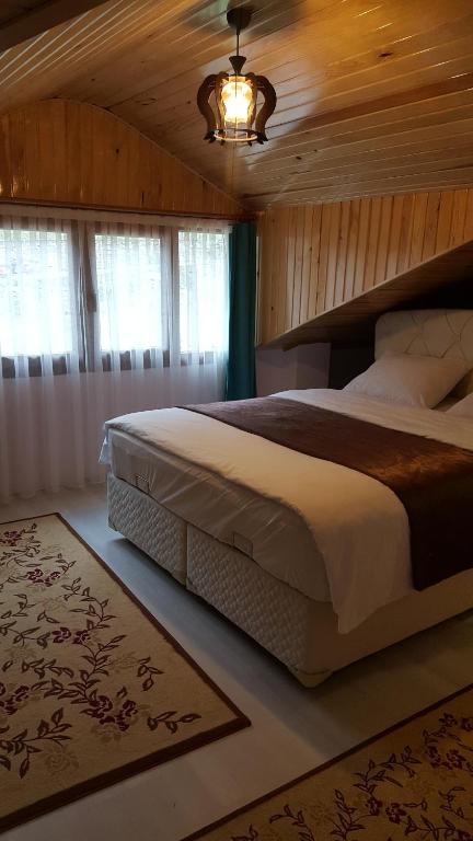 乌宗Uzungöl Özbek Apart ve Kafe的一间卧室设有一张带木制天花板的大床