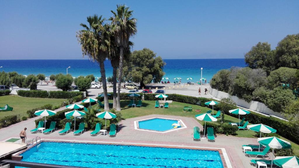 伊利索斯皮丽雅海滩酒店的享有带遮阳伞的游泳池和大海的顶部景致
