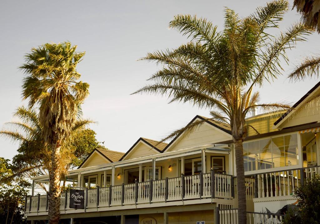 欧尼罗亚奥斯特酒店的前面有棕榈树的房子
