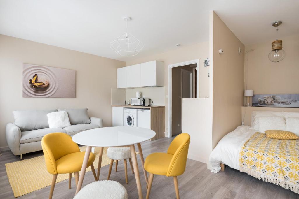里昂Appartement Lyon Gerland - Enjoy in Lyon的小房间设有一张床、一张桌子和椅子
