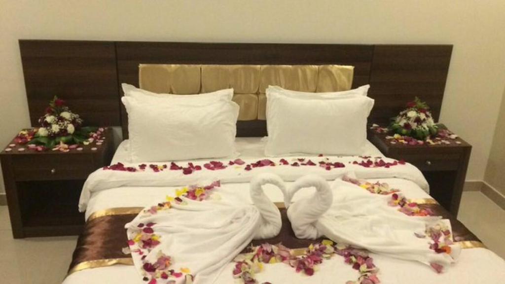 塔伊夫Rans Chalets的一张配有白色床单和鲜花的大床