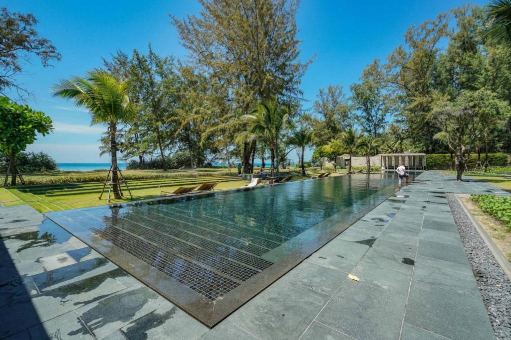 迈考海滩Baan Mai Khao的树木繁茂的公园中央的游泳池