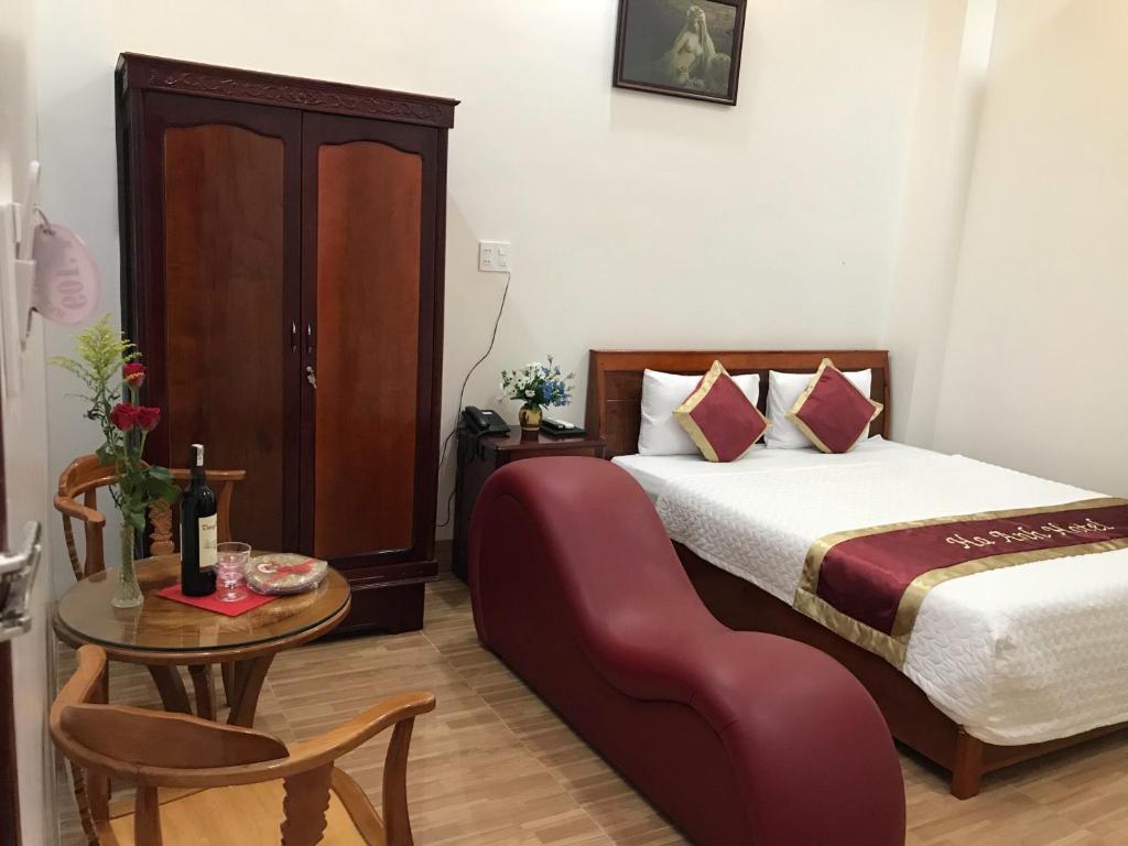 Cao LãnhHa Anh Hotel的一间卧室配有一张床和一张桌子及椅子