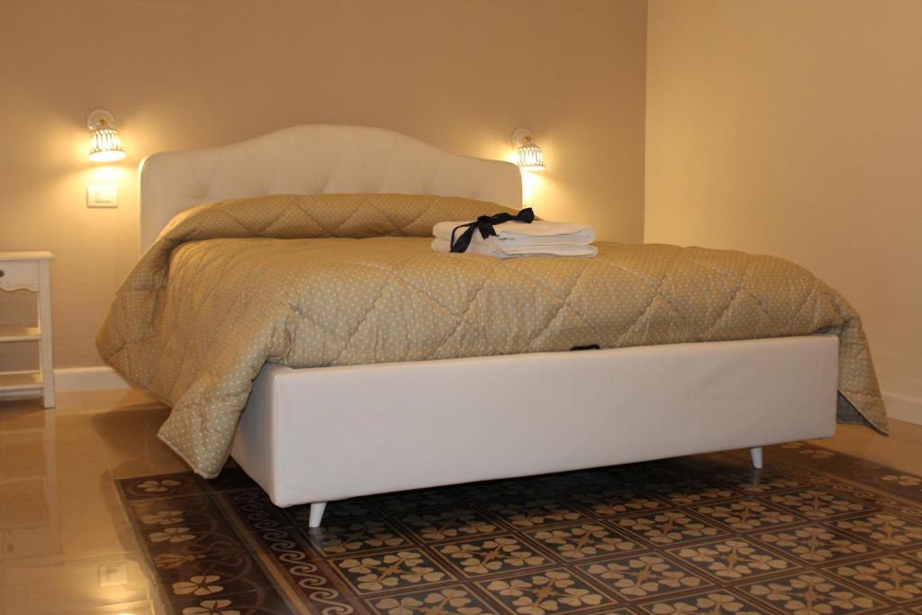 卡斯泰拉内塔B&B Palazzo Rochira的一张白色的床,上面坐着一只猫