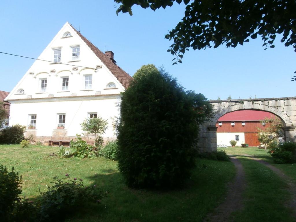 BožanovPenzion Zemanův Dvůr的一座大白色房子,院子里有大灌木丛