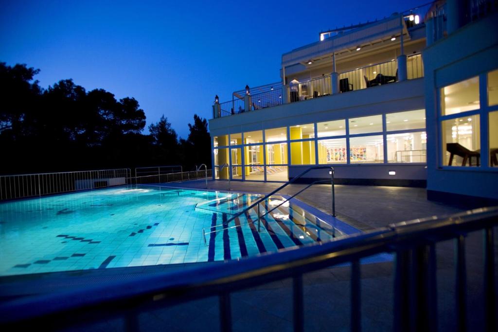 木洛希尼欧若拉酒店的一座游泳池,在晚上在建筑物前