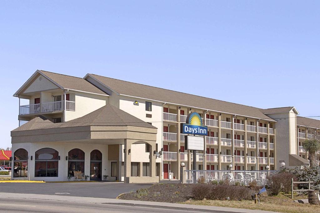 鸽子谷Days Inn by Wyndham Apple Valley Pigeon Forge/Sevierville的酒店大楼前面有酒店标志