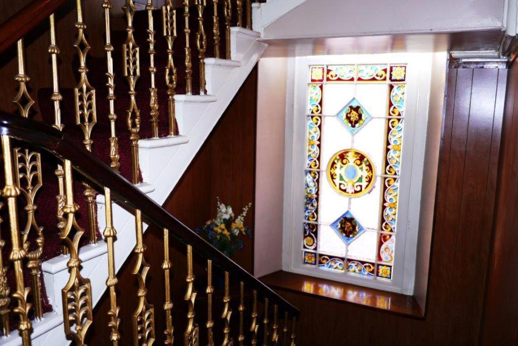 埃尔金Elgin Guest House的墙上有彩色玻璃窗的楼梯