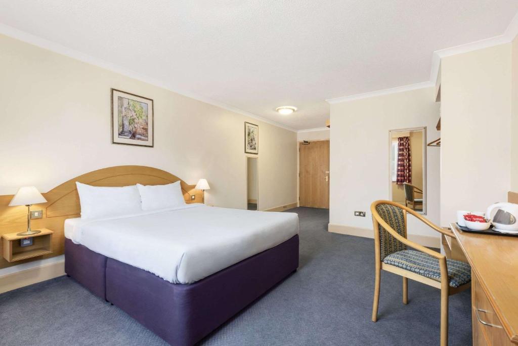 克里克怀特夫德盖普戴斯旅馆的酒店客房设有一张大床和一张书桌。