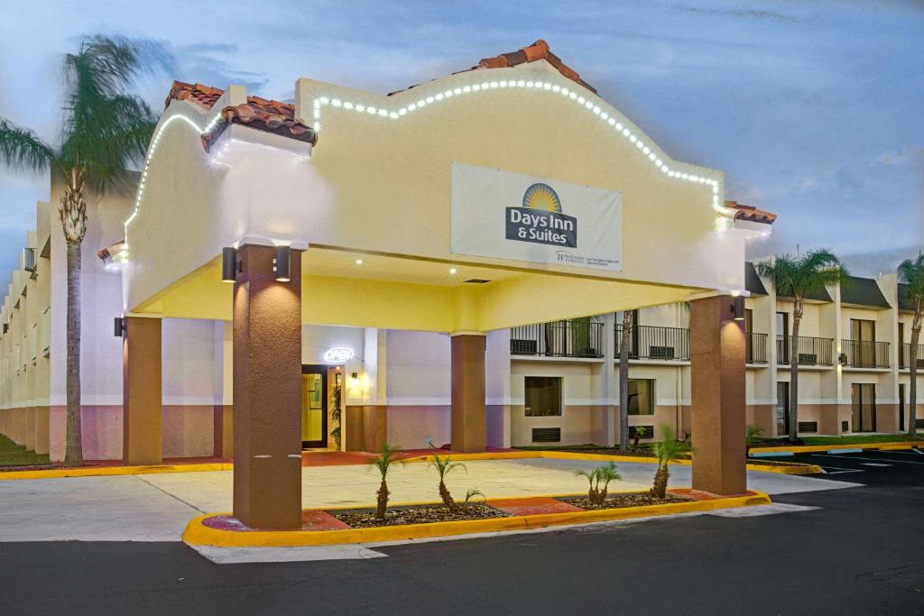 坦帕Days Inn & Suites by Wyndham Tampa - Ybor City的一座酒店大楼,前面有标志