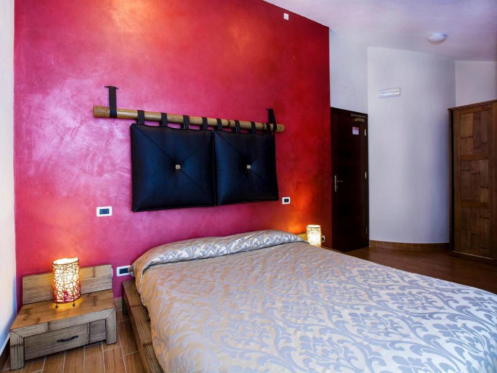 韦莱特里伊尔法尔科农家乐的一间卧室设有一张床和红色的墙壁