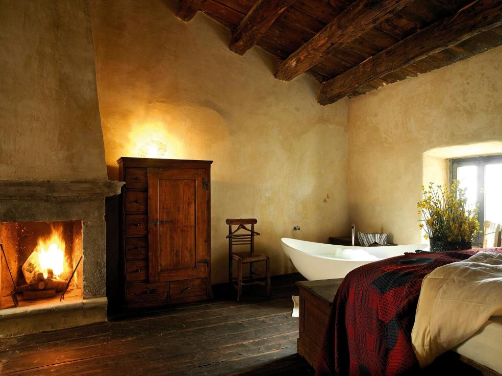 圣斯特凡诺·迪塞斯西克斯坦堤欧艾尔伯格迪富索酒店的一间带浴缸和壁炉的卧室