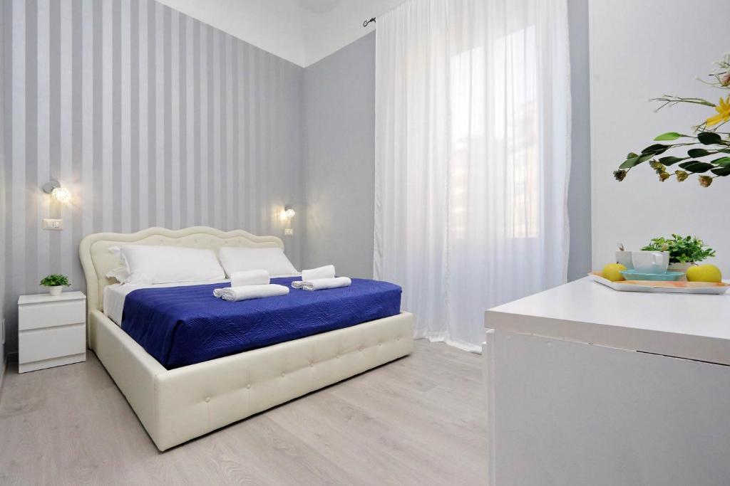 罗马Domus Domas - Golden Keys Collection的白色卧室配有一张带蓝色毯子的床