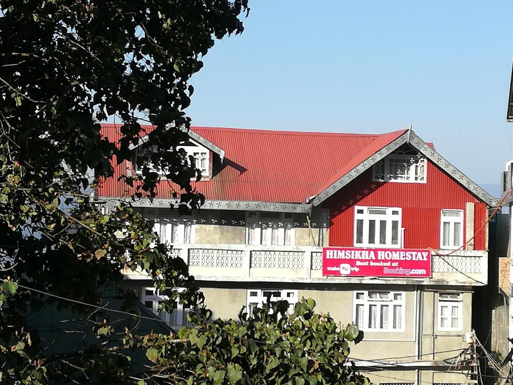 大吉岭Himshikha Homestay的红色的建筑,有红色的屋顶