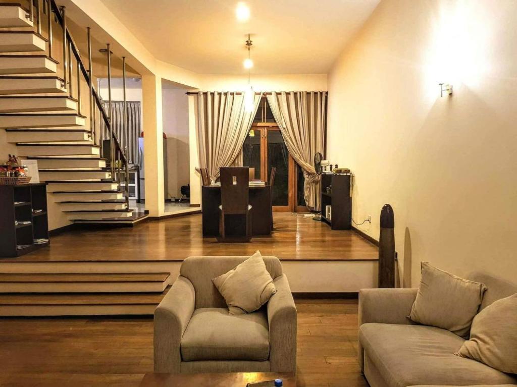 科伦坡Occazia Residence的客厅设有两张沙发和一个楼梯