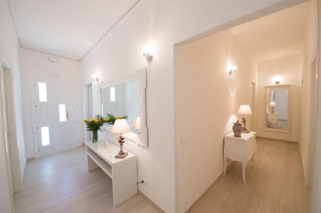 法维尼亚纳Donna Maria b&b的一间白色的房间,配有两张桌子和两盏灯