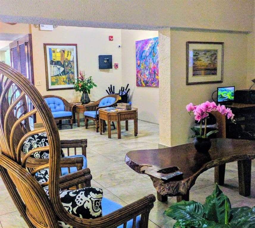 圣胡安Canario Lagoon Hotel的客厅配有椅子和鲜花桌子
