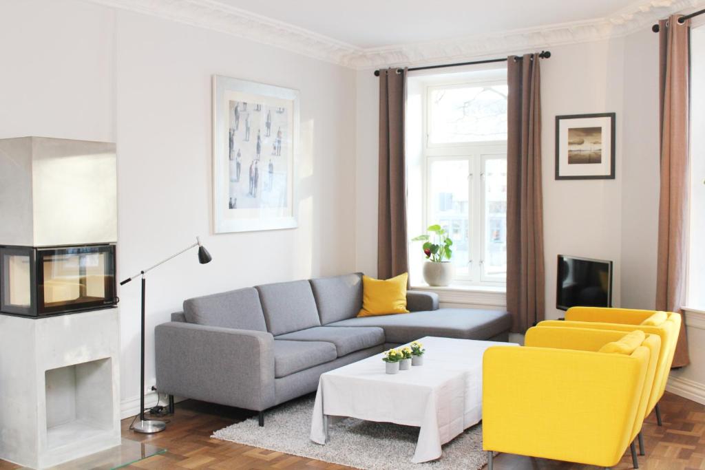 奥斯陆北欧旅舍 - 德施曼门10号的客厅配有灰色的沙发和黄色的椅子